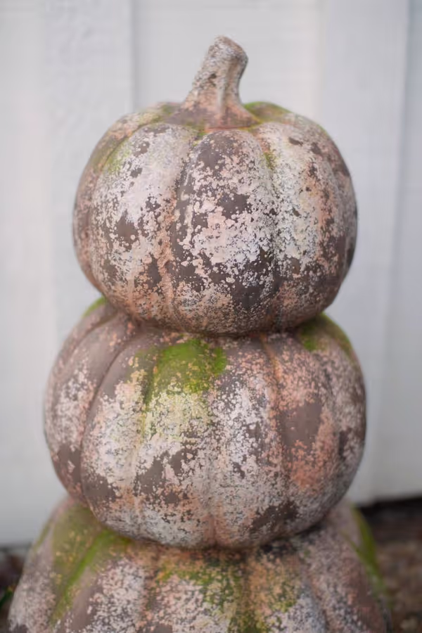 three stacked faux concrete pumpkins