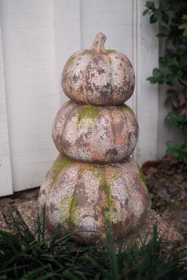 three stacked faux concrete pumpkins