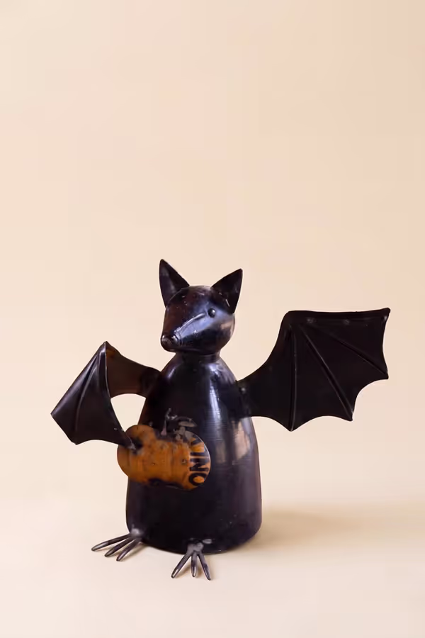 Recycled Metal Bat Holding a Pumpkin